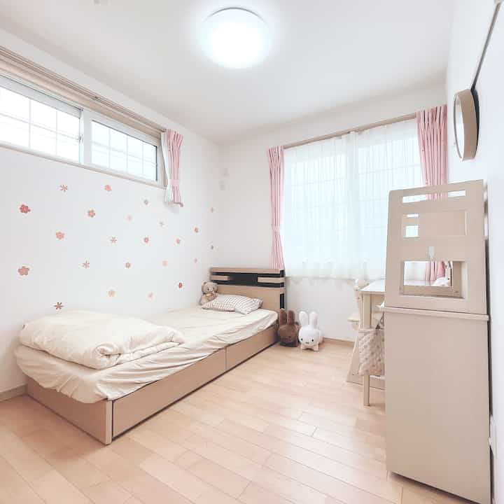 Natural tone kids' room featuring beige bed and desk with a clean and charming atmosphere