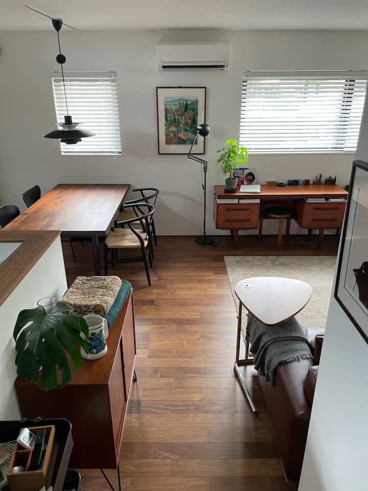 Natural brown wood tone and white walls harmonize in a living and dining room, creating a modern yet warm atmosphere