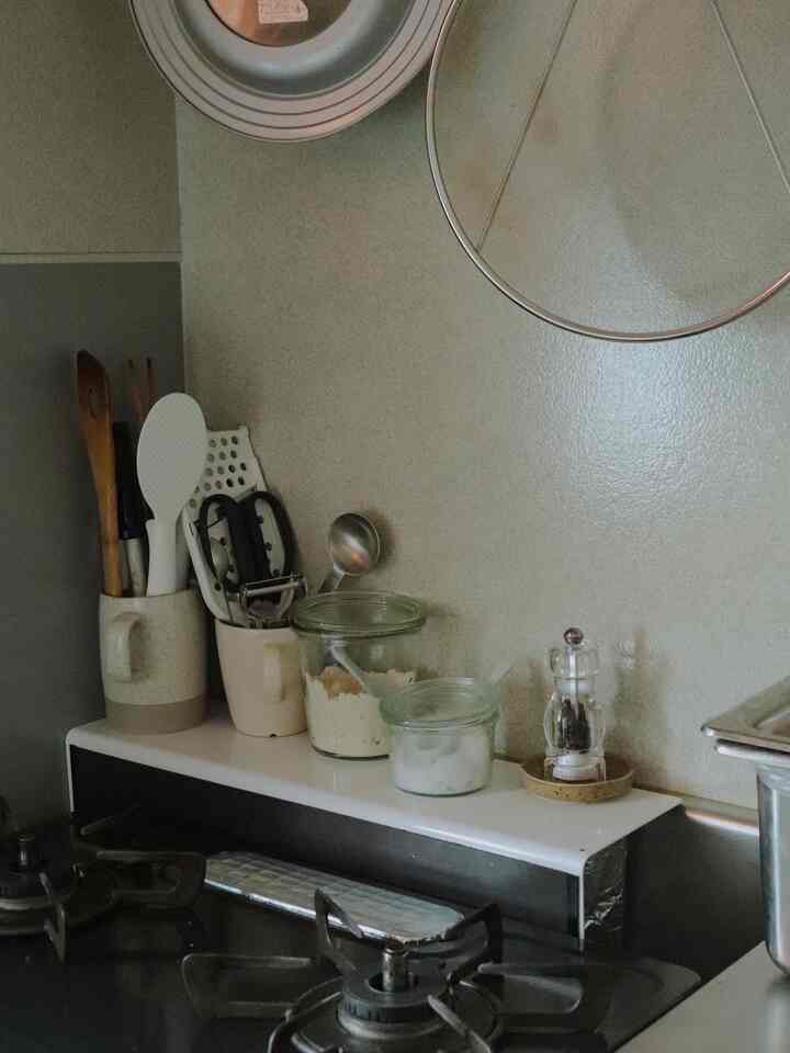 Warm beige-toned kitchen featuring neatly arranged kitchen utensils and transparent glass containers, creating a cozy atmosphere