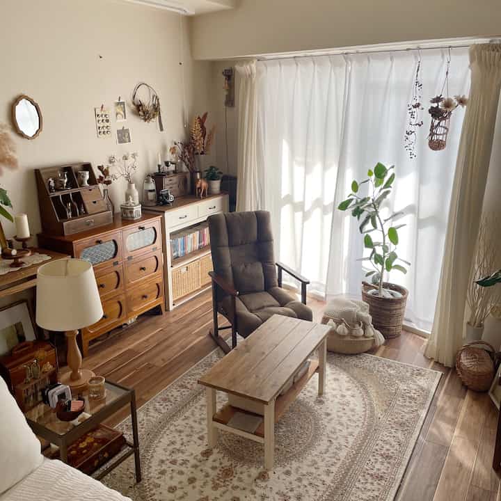 Ivory-colored walls and beige rug in a natural brown toned living room featuring an armchair and coffee table at center, cozy atmosphere