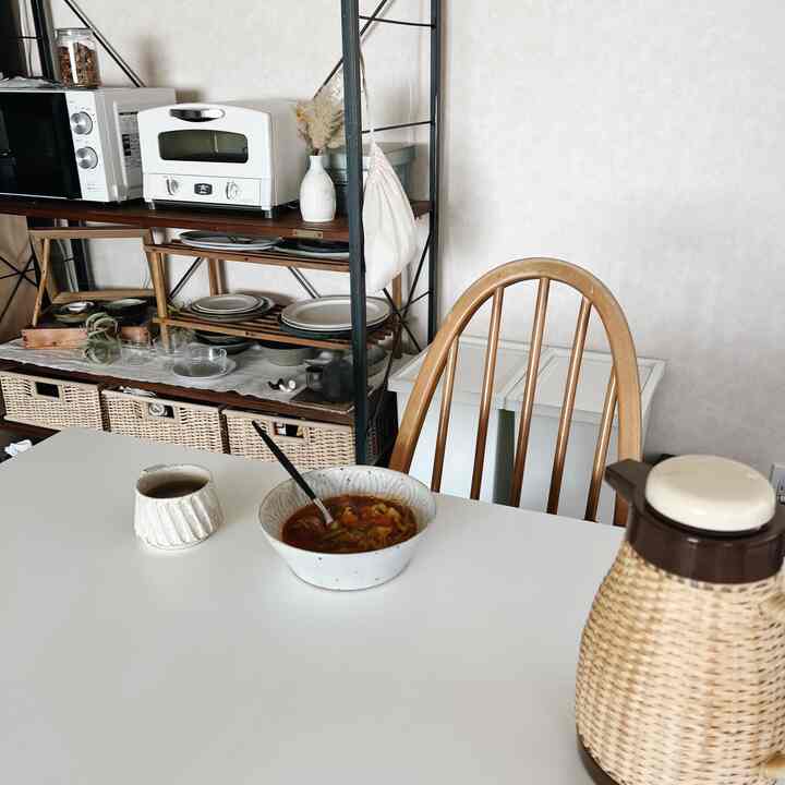 アイボリーの壁と木目調のダイニングチェアがあるキッチンダイニング、清潔感と温かみのある雰囲気