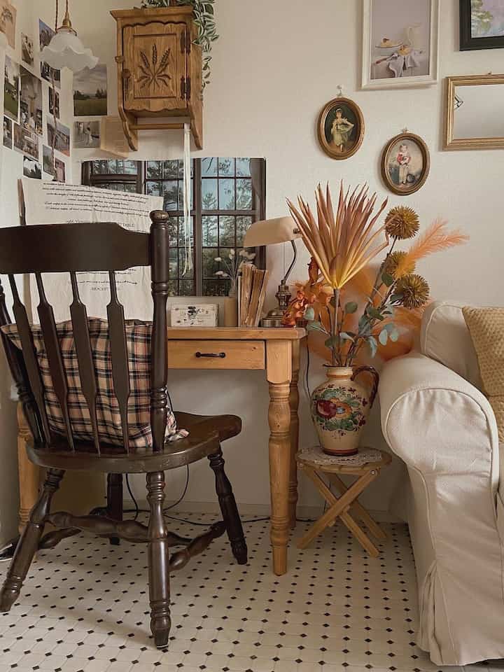 Natural wood tones and white sofa in a French country style home office space with rustic decor items