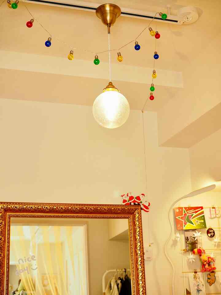 Warm indoor space with white and gold tones featuring a large mirror and Christmas decorations