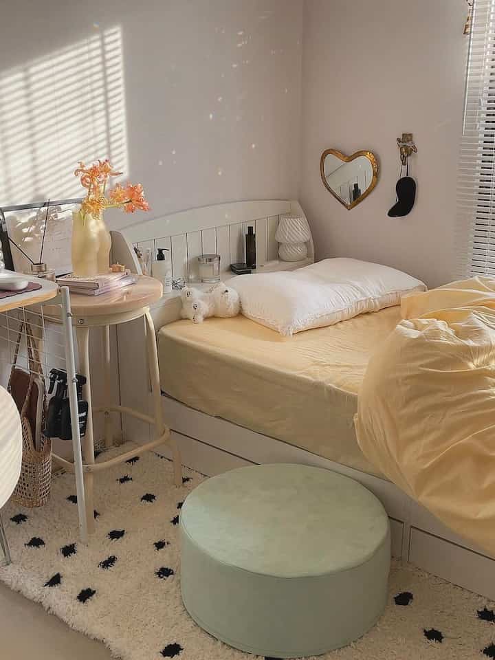 Beige-toned bedroom featuring a white bed and soft stool with a cozy atmosphere