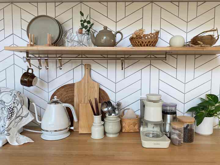 白と木目調の調和が感じられるキッチン、シンプルなインテリアとscopeのキッチンツールキャニスターが配置された雰囲気のある空間