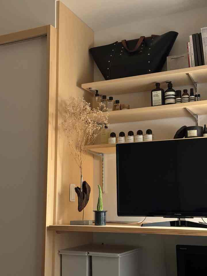 ナチュラルな木目調の書斎、モニター、デスク、3つの棚が整然と配置された雰囲気のあるインテリア