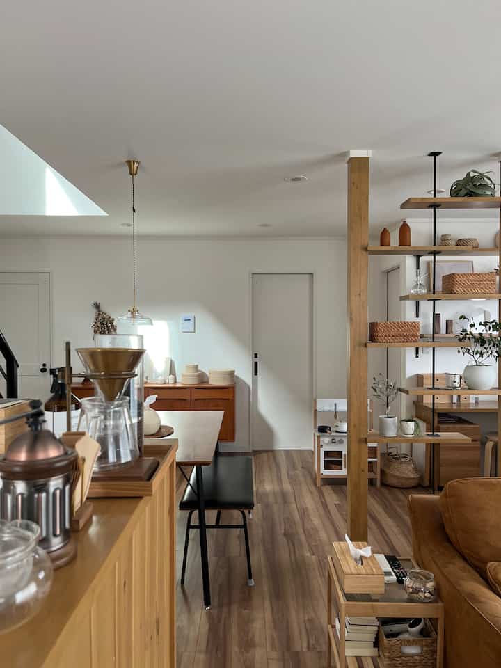 ナチュラルな木目調と白い壁が調和するダイニングとリビングスペース、ハンドドリップコーヒーセットが配置された温かみのあるおうちカフェの雰囲気