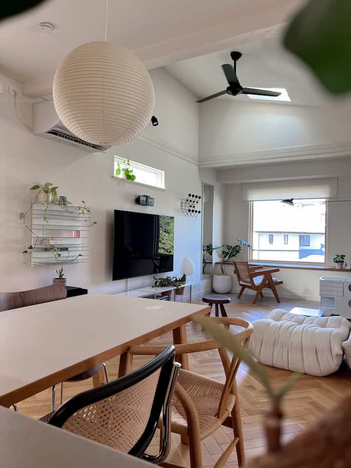 A natural-toned living room featuring wooden furniture and a pendant light, bright and clean interior design