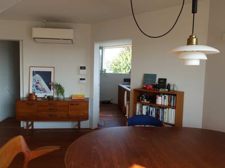 暖かい木目調と白い壁が調和した、北欧スタイルのリビングとキッチンがつながる空間