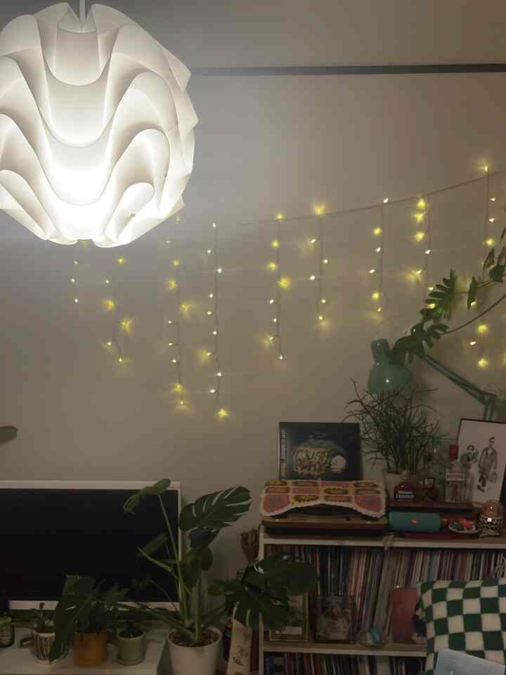 White-toned living room featuring Nordic pendant light and LED string lights creating a cozy atmosphere