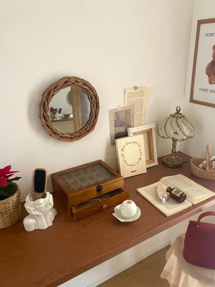 木目調と白を基調としたウォークインクローゼットの化粧台、ラタンの鏡と装飾品が配置された温かみのある空間