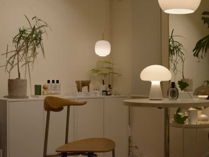 暖かい照明のナチュラルモダンなリビング、白い家具と植物が配置された雰囲気のある空間