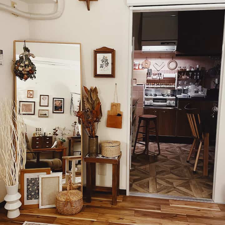 Natural toned living and dining room featuring wood furniture and a large wall mirror with a warm atmosphere