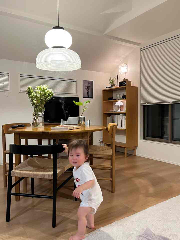 Warm dining room with white walls and wood-toned furniture, featuring a baby near the table creating a cozy atmosphere