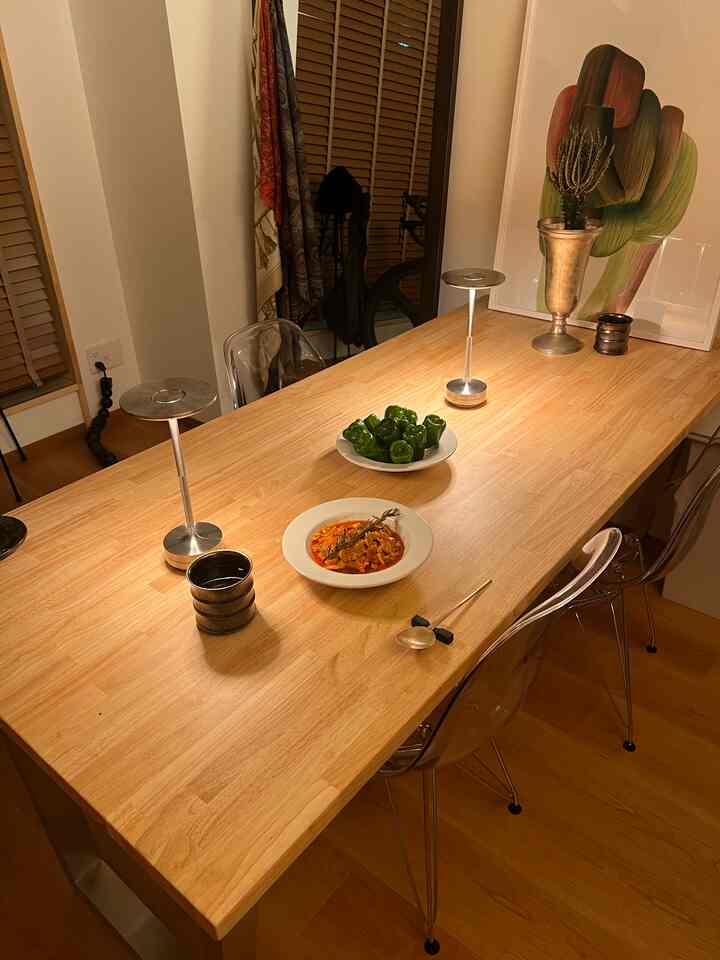 温かみのある木目調のダイニングルーム、透明な椅子とシンプルで落ち着いた雰囲気のテーブルが配置された印象的な空間