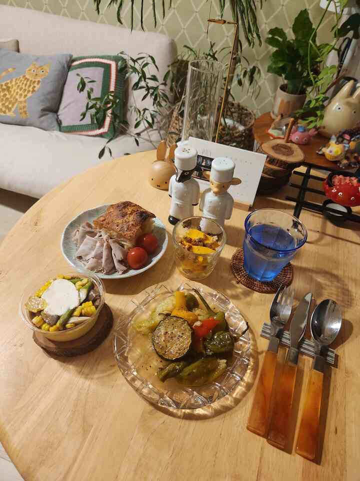 ベージュとナチュラルカラーのダイニング、木製テーブルとカトラリーが配置された雰囲気のある空間