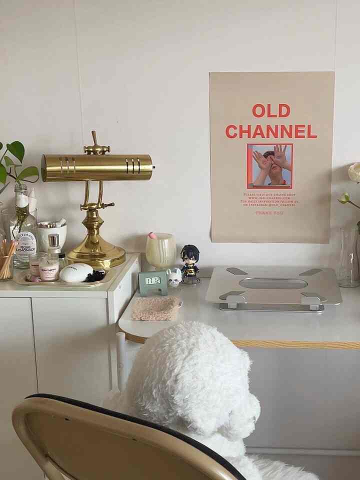 ホワイトとゴールドのトーンのホームオフィス、整頓されたデスクとゴールドの照明が配置されたシンプルなインテリア