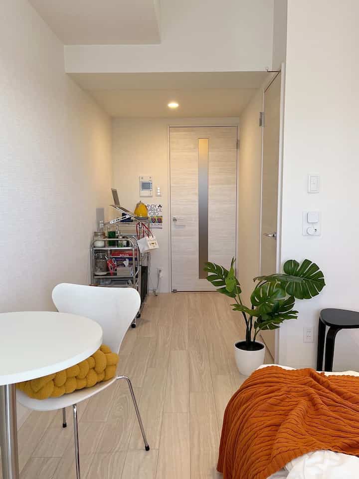 Natural color and white-toned L-shaped 8-tatami room featuring dining chair and monstera plant with cozy atmosphere