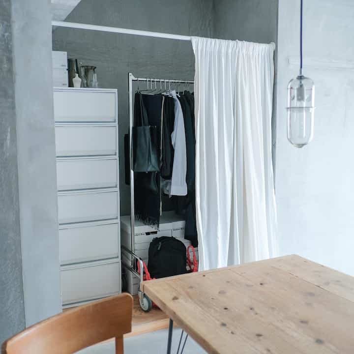 A compact space with white and natural color tones featuring a closet and neat storage ideas in a simple interior