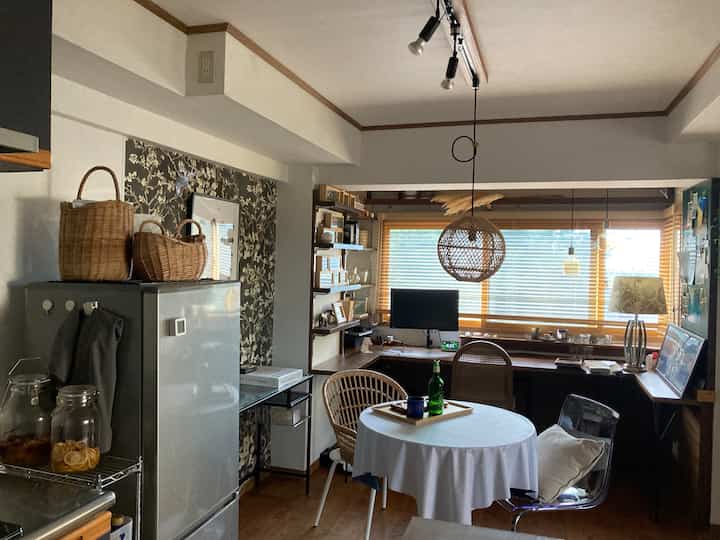 Natural wood tones and white kitchen and dining room featuring rattan furniture and baskets creating a warm atmosphere