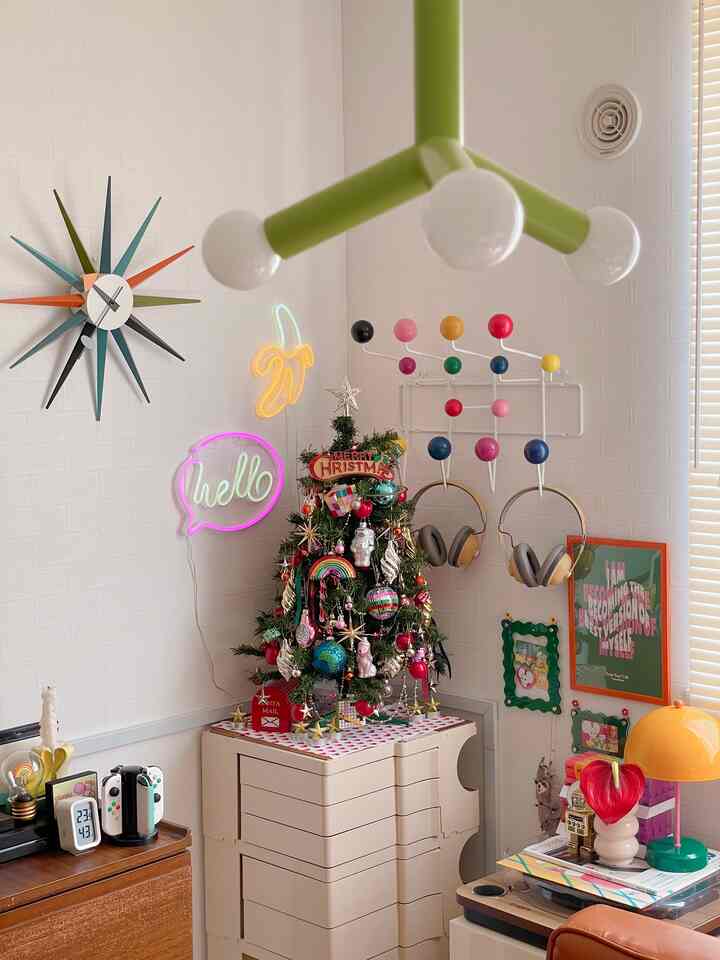 白い壁のミッドセンチュリーモダンスタイルの空間、カラフルなクリスマスツリーとネオンサインが印象的な雰囲気のあるインテリア