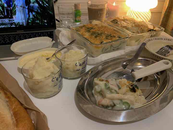 温かみのある照明とホームパーティーの食器が配置された白いダイニングスペース