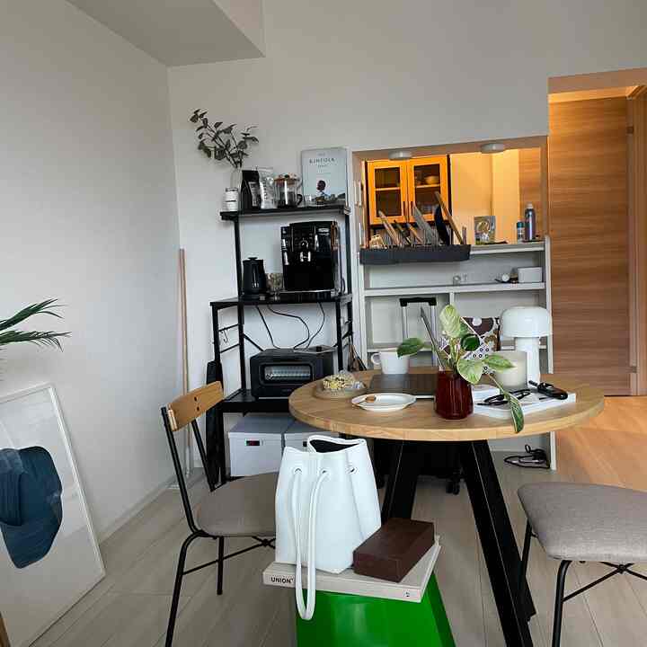Compact living room with white and wood tones, featuring a round dining table and stools in a natural modern style