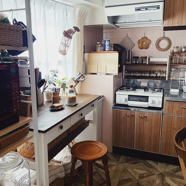 A cozy small kitchen in wood and beige tones featuring wooden furniture and coffee accessories for a home cafe setting