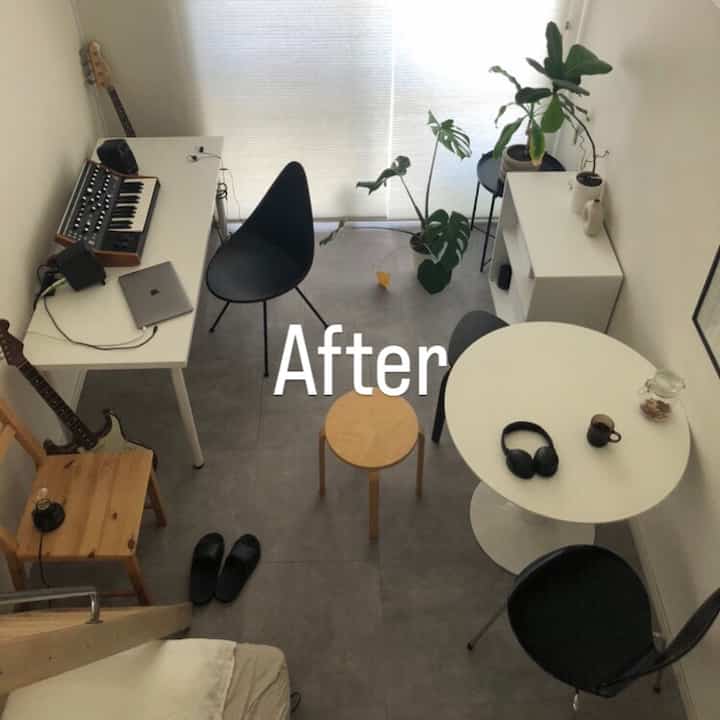 Minimalistic studio apartment home office with white and black tones, simple furniture, and plants harmoniously arranged
