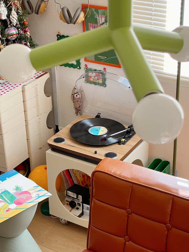 白い壁とグリーンのペンダントライトが配置されたミッドセンチュリーモダンの小さなレトロなリビングスペース