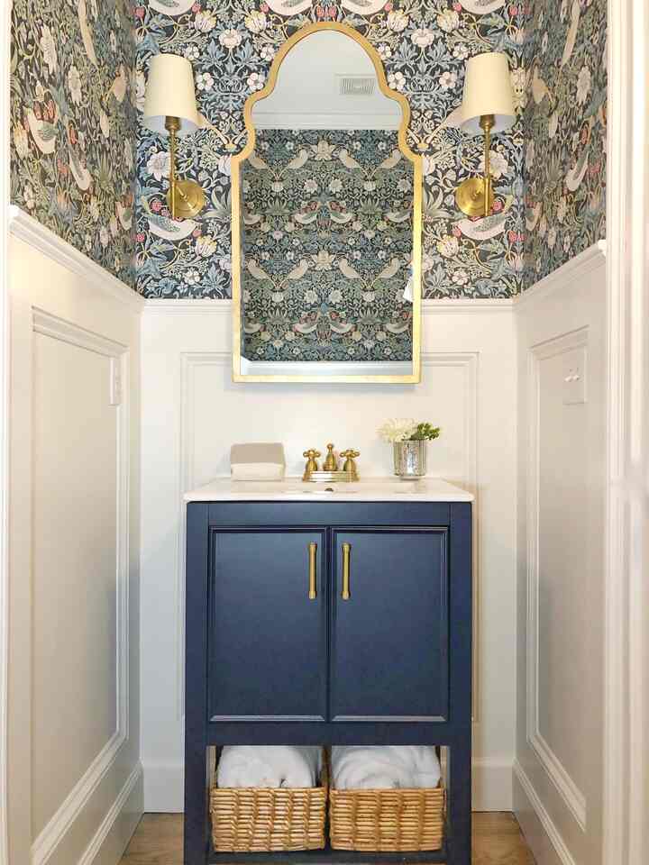 Navy-toned powder room featuring Strawberry Thief wallpaper, gold accents, and a stylish bathroom vanity creating an instagrammable vibe