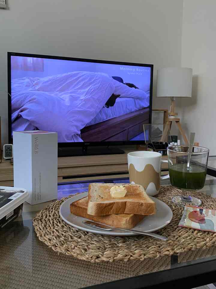 ホワイトとウッドトーンが調和したリビング、テレビ台とフロアランプが配置された落ち着いた雰囲気のあるおうちカフェ空間