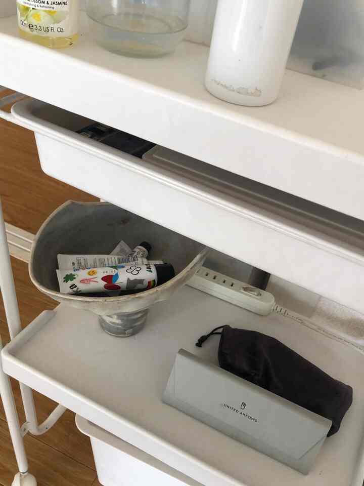 ホワイトとブラウンの色調のリビング周り、白いトレイと小さな収納カートが調和した清潔感のあるインテリア