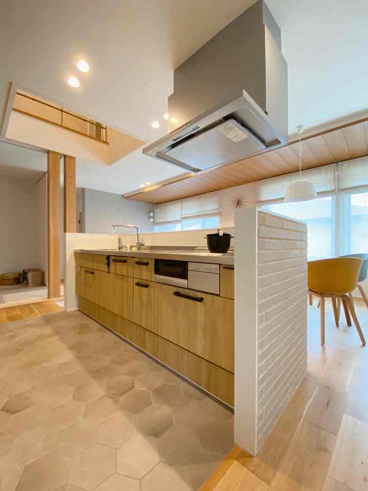 白と木目調が調和したカフェ風キッチンとダイニング、広く明るい雰囲気のインテリア