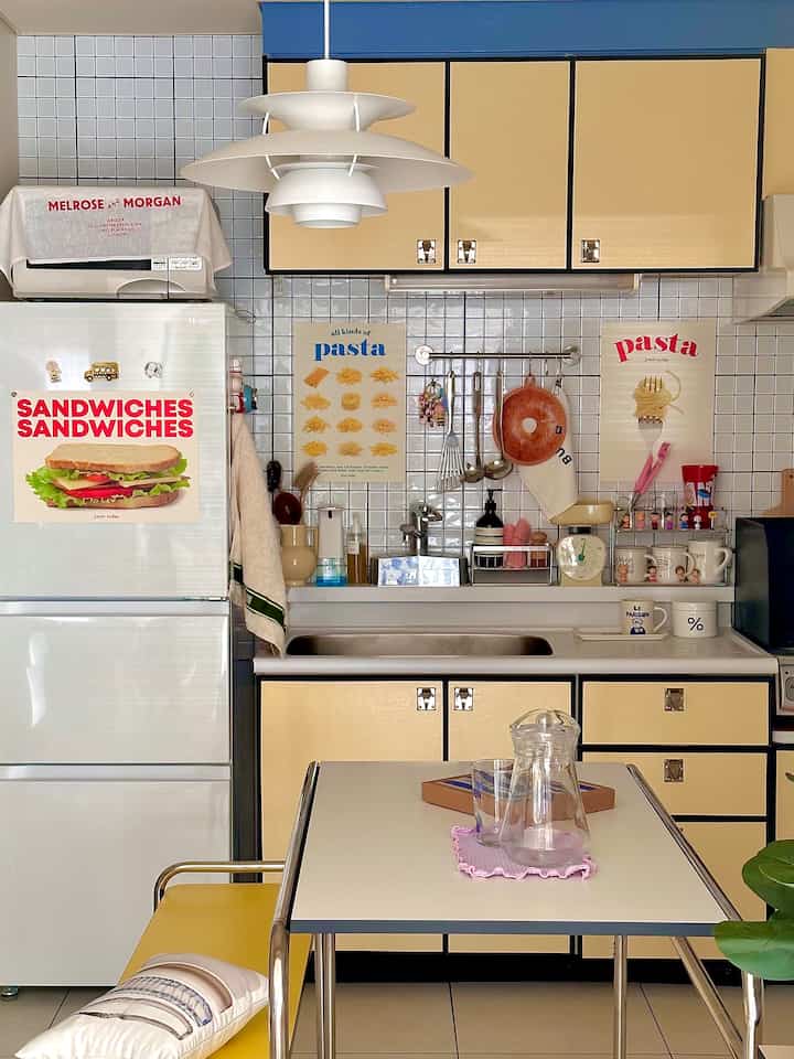 Yellow-toned kitchen space featuring pendant light and dining table with a cozy atmosphere