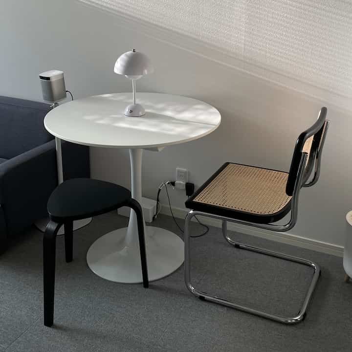 Bright room with minimalist white, black, and natural toned round table and chairs creating a modern atmosphere