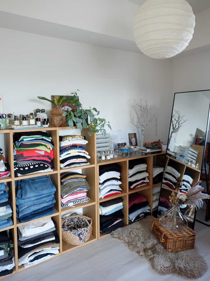 Natural tone closet space featuring built-in shelving and a full-length mirror with a simple aesthetic