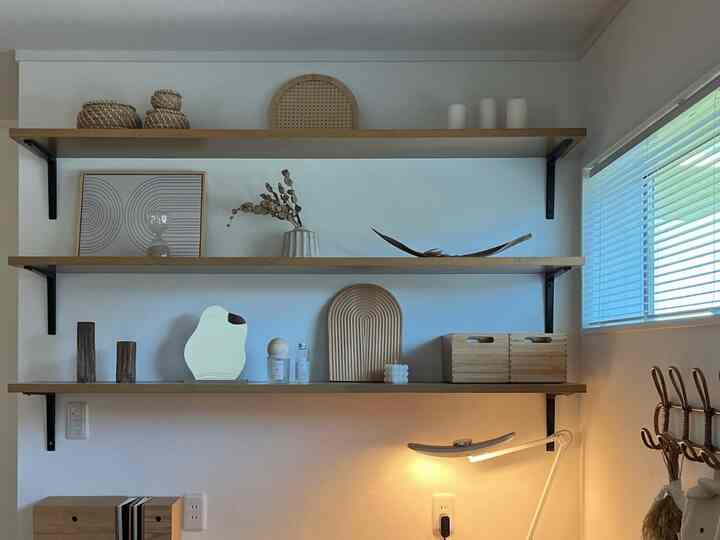 White walls and natural wood trays in a simple desk space featuring tidy storage ideas in a clean home office interior