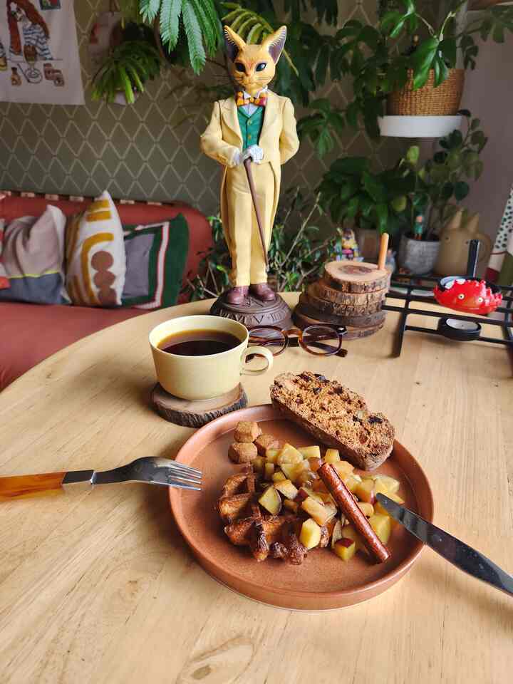 Warm wood tone table featuring vintage accessories with coffee and snacks in a cozy home cafe setting