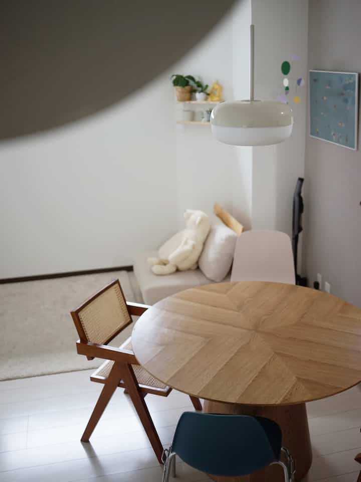 Light brown and white toned dining room featuring a round dining table and chairs in a simple natural atmosphere