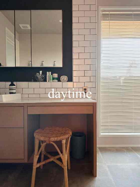 ナチュラルな色調のバスルーム、白いタイル壁と木製の化粧台が配置された清潔感のあるモダンなインテリア