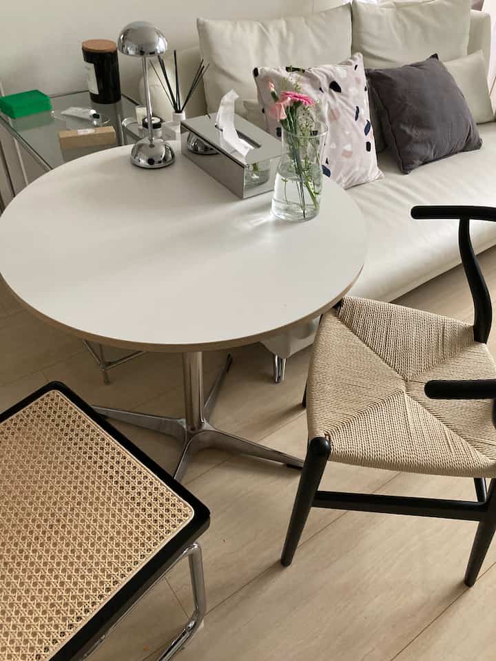 白とナチュラルカラーのリビング兼ダイニング、丸テーブルとティッシュボックス、2脚の椅子が配置されたシンプルモダンな空間