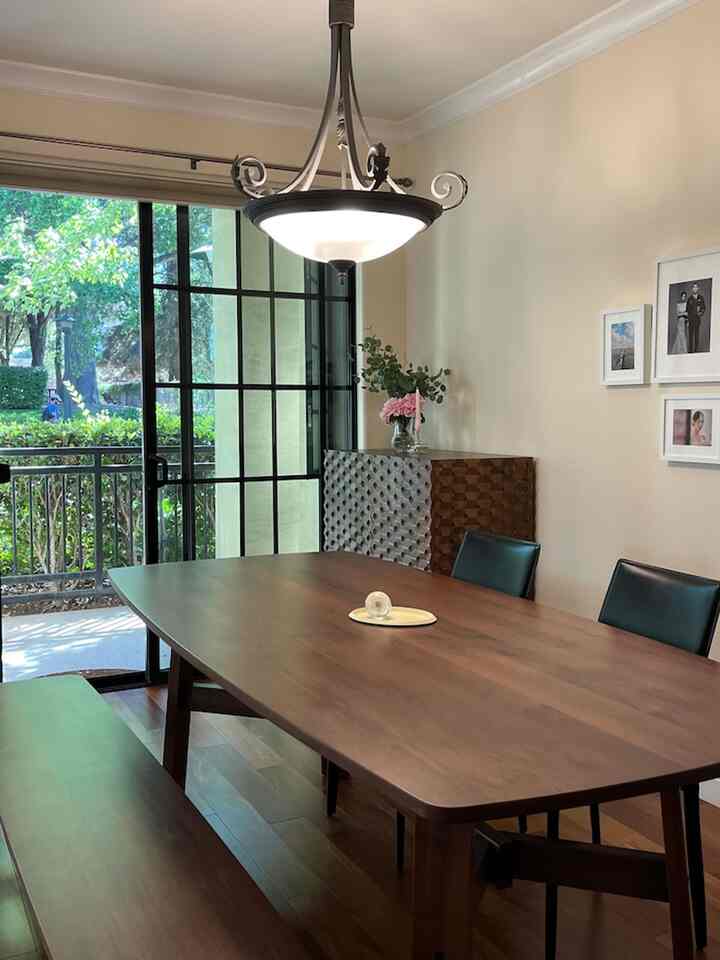 Beige-walled dining room with wood-tone furniture featuring a large dining table and chairs with a warm, inviting atmosphere