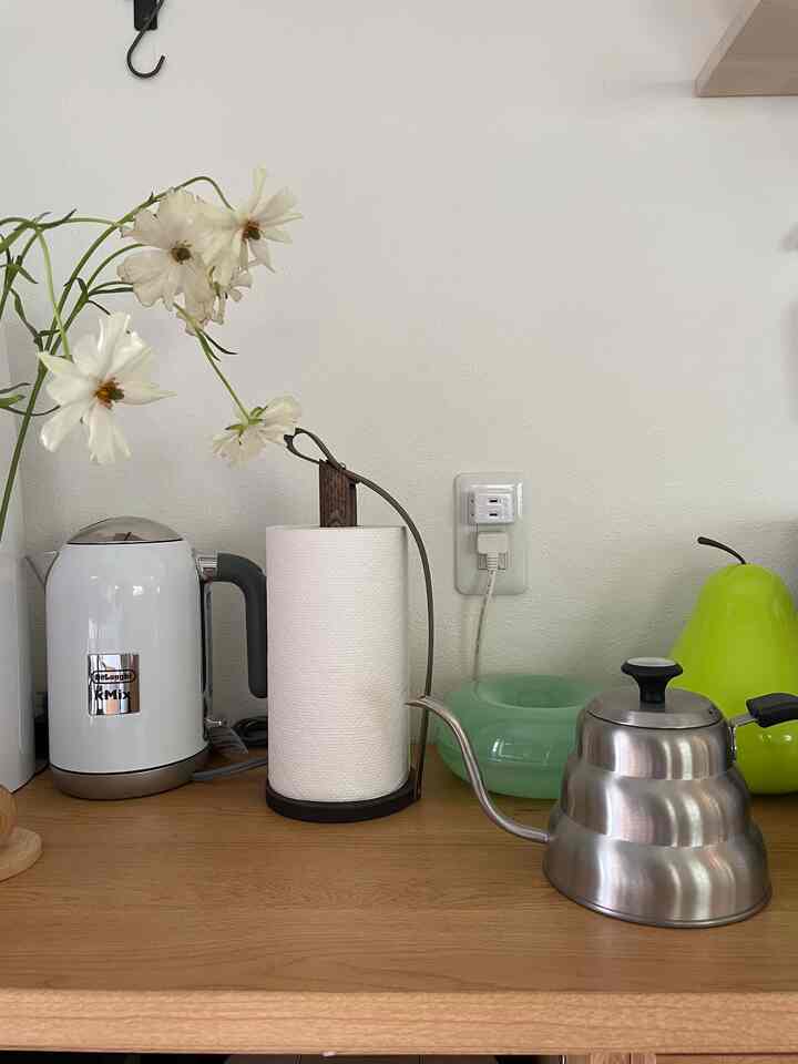 ナチュラルカラーのキッチン、木目調カウンターにキッチン用品とキッチンペーパーが配置された清潔感のあるインテリア