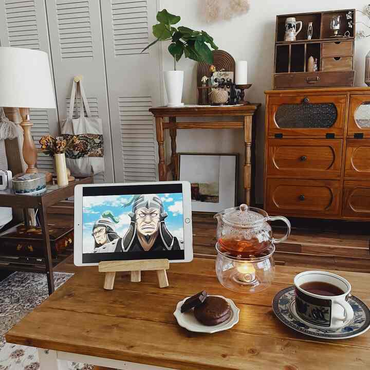 ナチュラルモダンな木目調のリビング、ティーウォーマーやお茶菓子が置かれた居心地の良いおうちカフェの空間