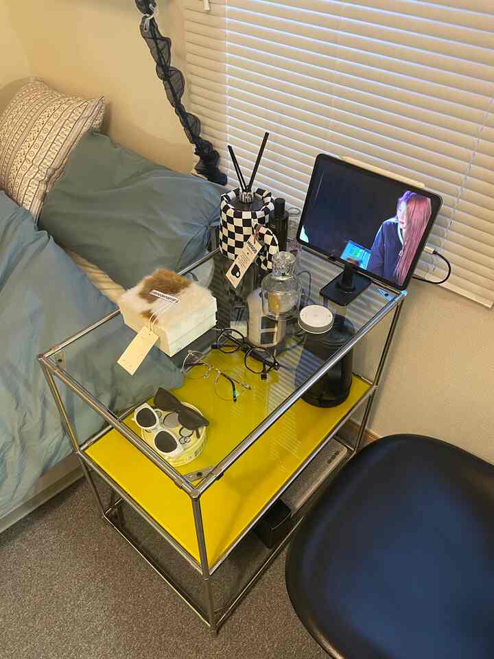 黄色の収納ラックがある一人暮らしの寝室、ホームオフィス空間とベッド、黒い椅子が配置されたインテリア