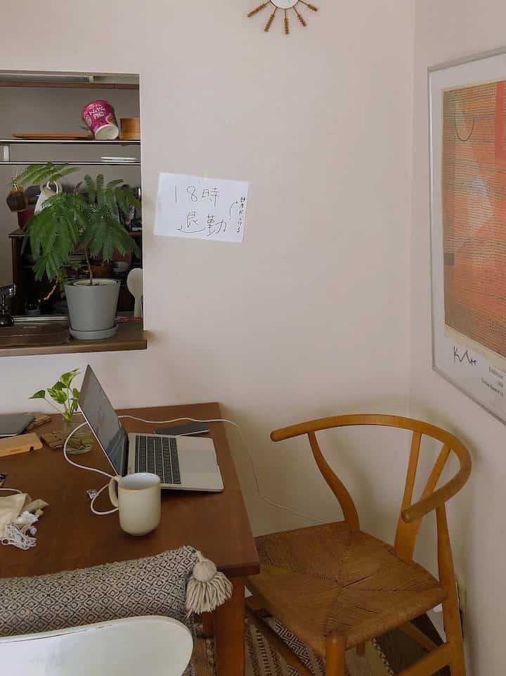 Natural brown tone home office space featuring simple wooden furniture and a laptop with cozy atmosphere
