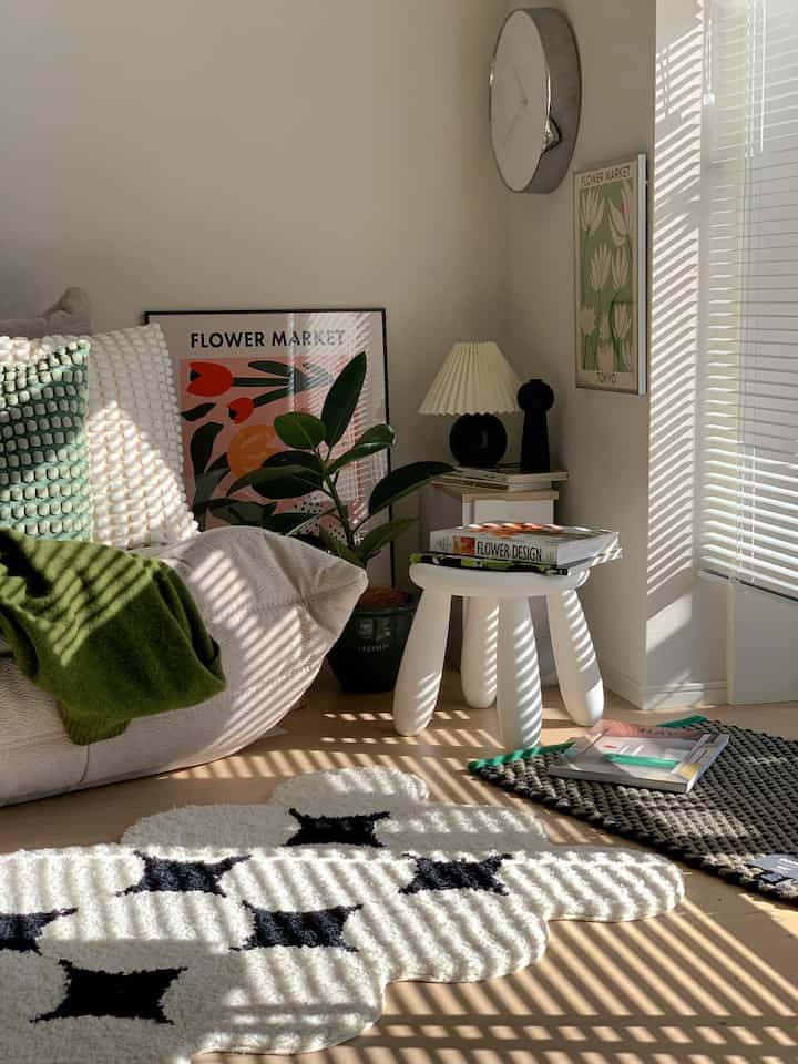 白とベージュのトーンが特徴的なリビング、日差しとブラインドの影が織りなす自然で心地よいインテリア