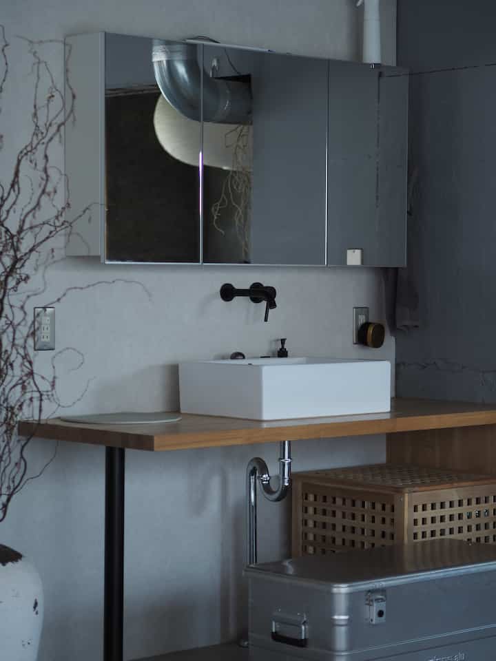Modern living room corner with white vanity on wood tone countertop in a compact space