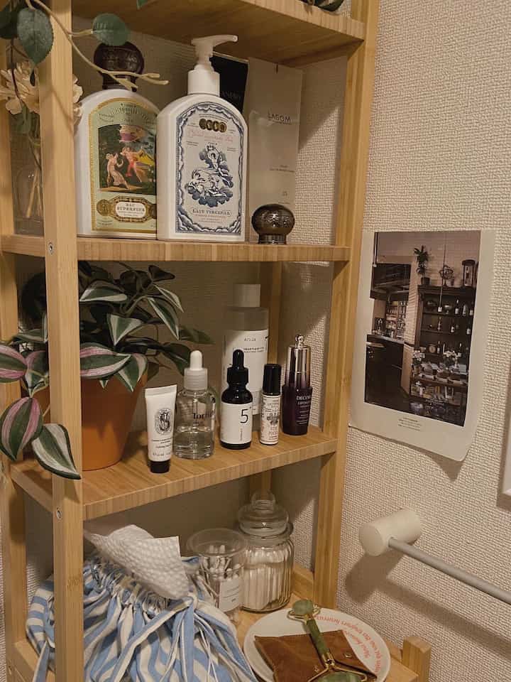 木目調のバスルームの一角にIKEAラックがあり、スキンケア用品と化粧品が整然と並べられた落ち着いた空間